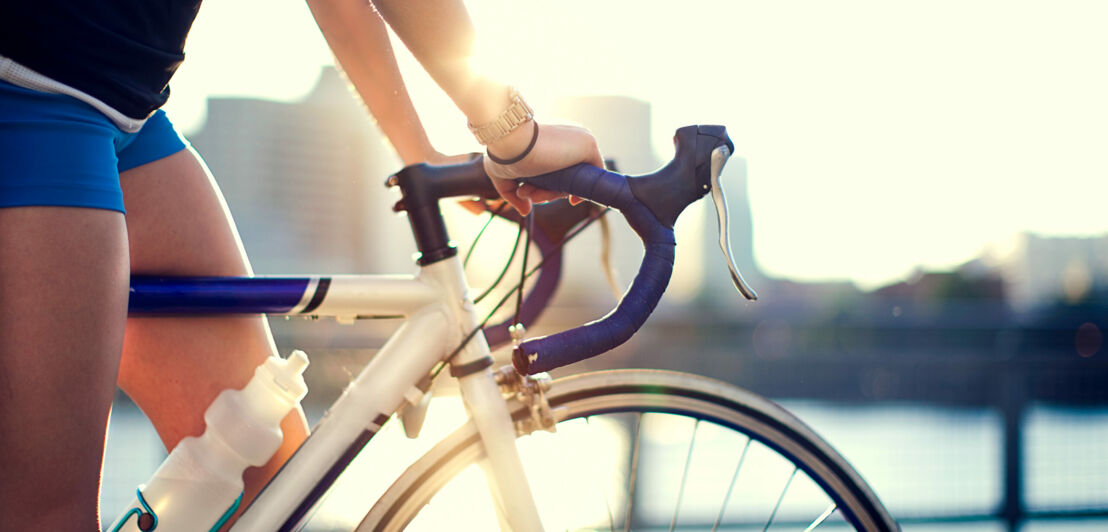 Eine Frau stützt sich auf einem Rennrad ab