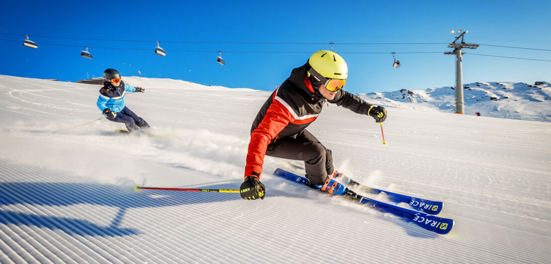 Zwei Alpinskifahrer:innen bei der Abfahrt in Parsenn