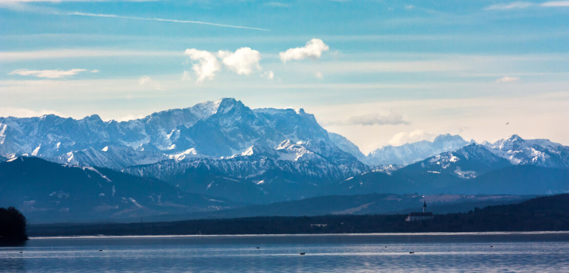 Ein See vor einer Alpenbergkette