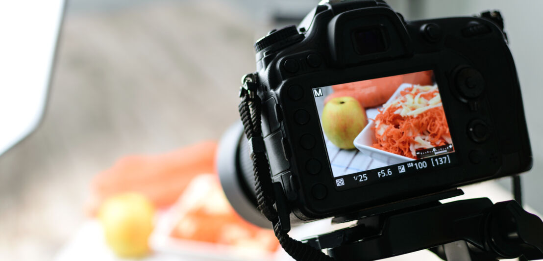 Rückansicht einer Kamera auf Stativ, die ein Gericht fotografiert