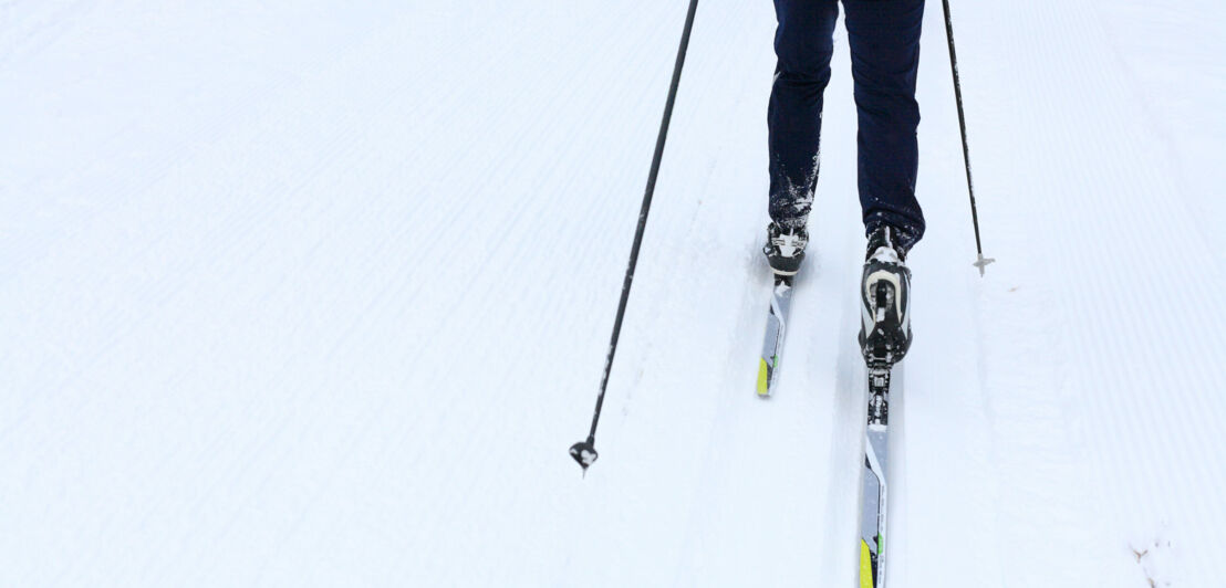 Eine Person auf Langlaufskiern im Schnee.