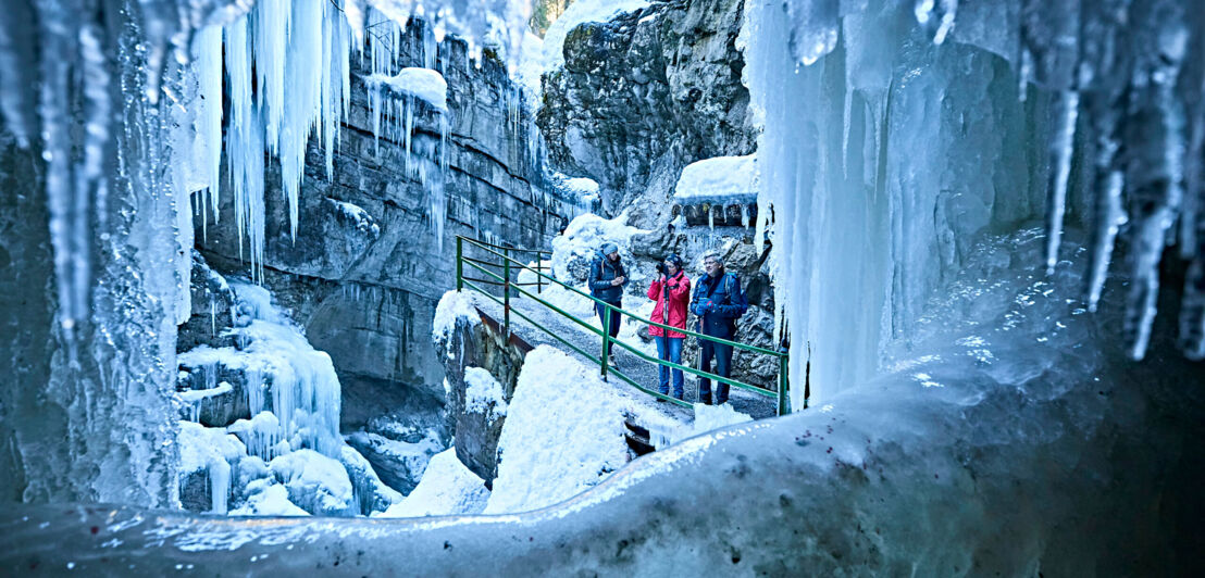 Drei Wanderer in der vereisten Breitachklamm