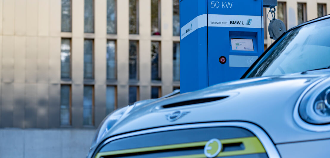 Ein Mini E-Auto steht im Winter an einer Ladesäule.