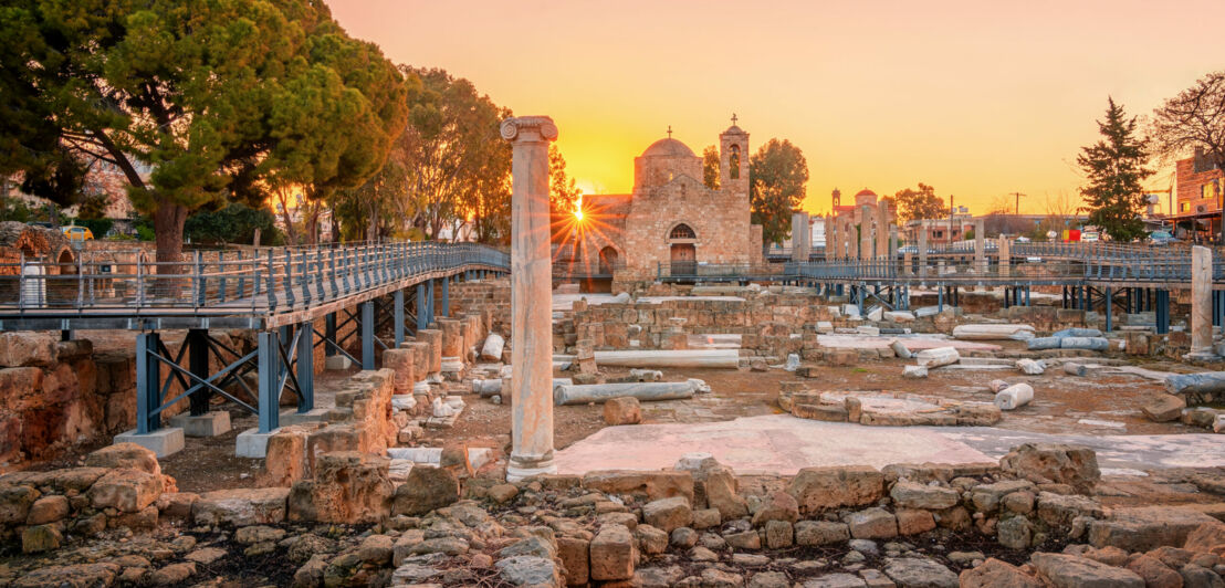 Archäologische Ausgrabungsstätte mit mediterraner Vegetation im Sonnenuntergang