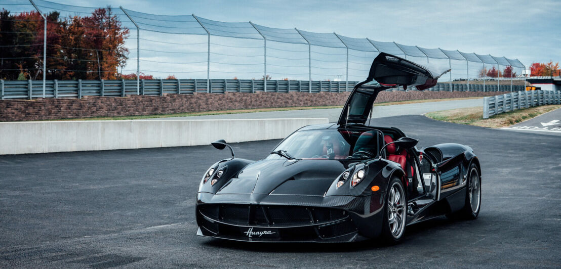 Der Sportwagen Pagani Huayra mit offener Flügeltür auf einer Rennstrecke.