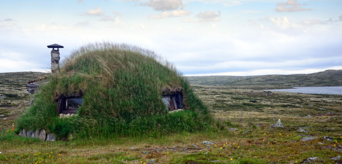 Ein Erdhaus aus Grasboden mit Fenstern und Schornstein in der Tundra