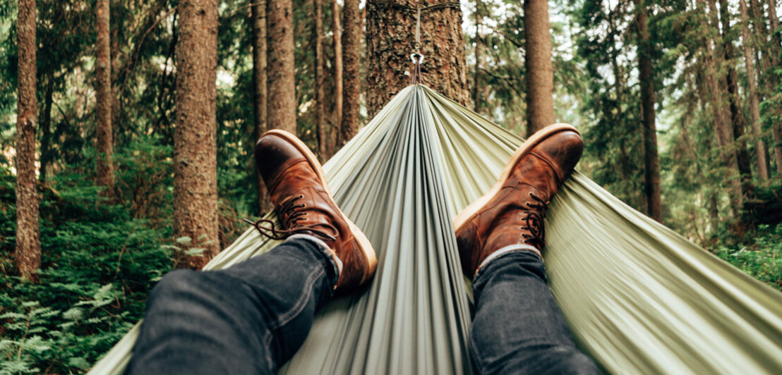 Mann entspannt in einer Hängematte im Wald