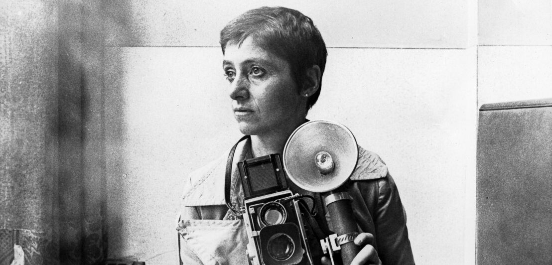 Diane Arbus posiert mit einer großen Kamera