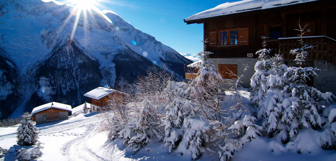 Mehrere Holzhütten in einer verschneiten Berglandschaft