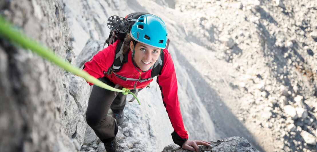 Eine Frau beim Klettern im Gebirge