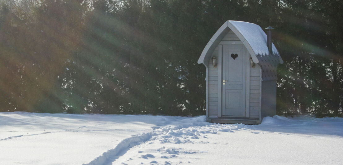 Kleine Sauna in einem verschneiten Garten