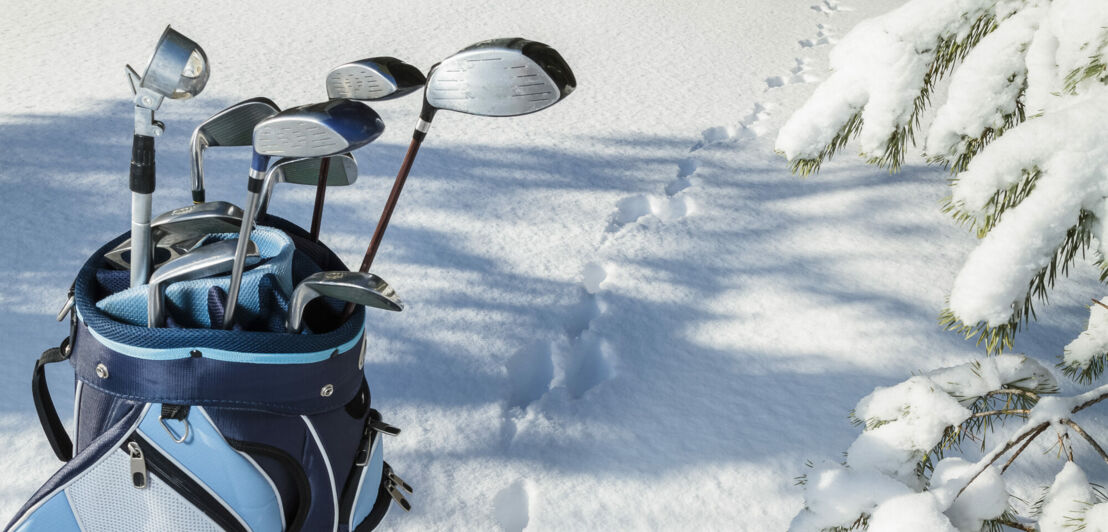 Eine Golftasche mit Schlägern im Schnee