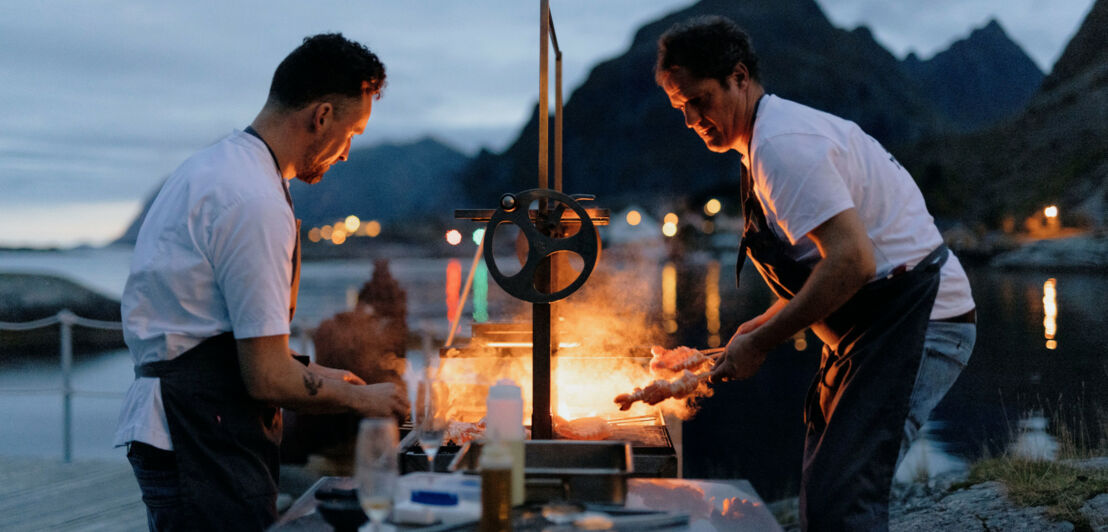 Valentine Warner und Richard Cox grillen draußen vor dem Hotel Holmen Lofoten