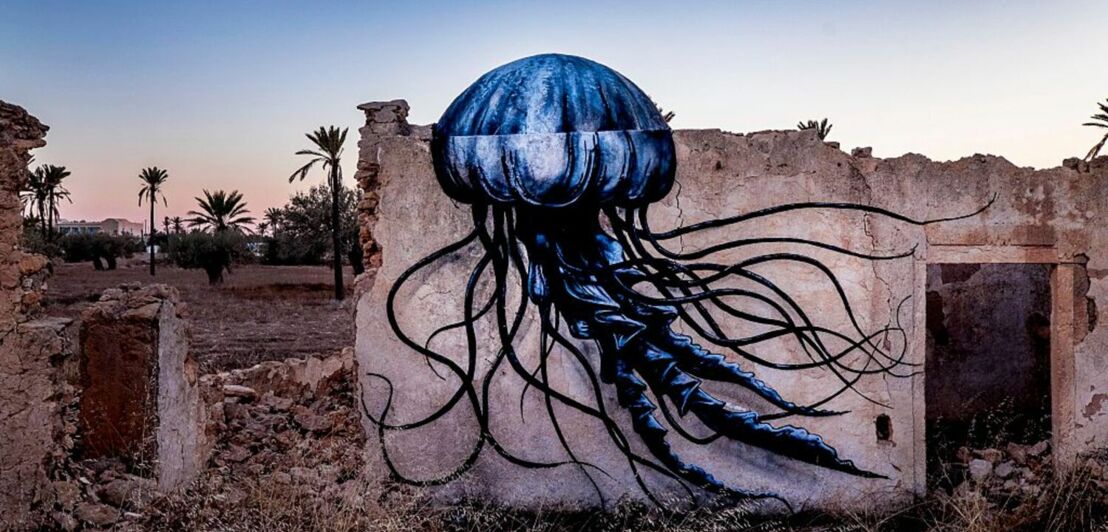 Eine blau-schwarze Qualle des Künstlers ROA auf einer Ruinenmauer in Tunesien.