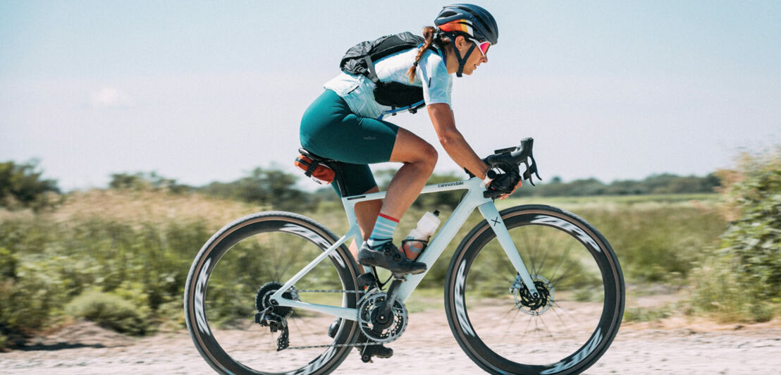 Eine junge Frau auf einem Gravelbike