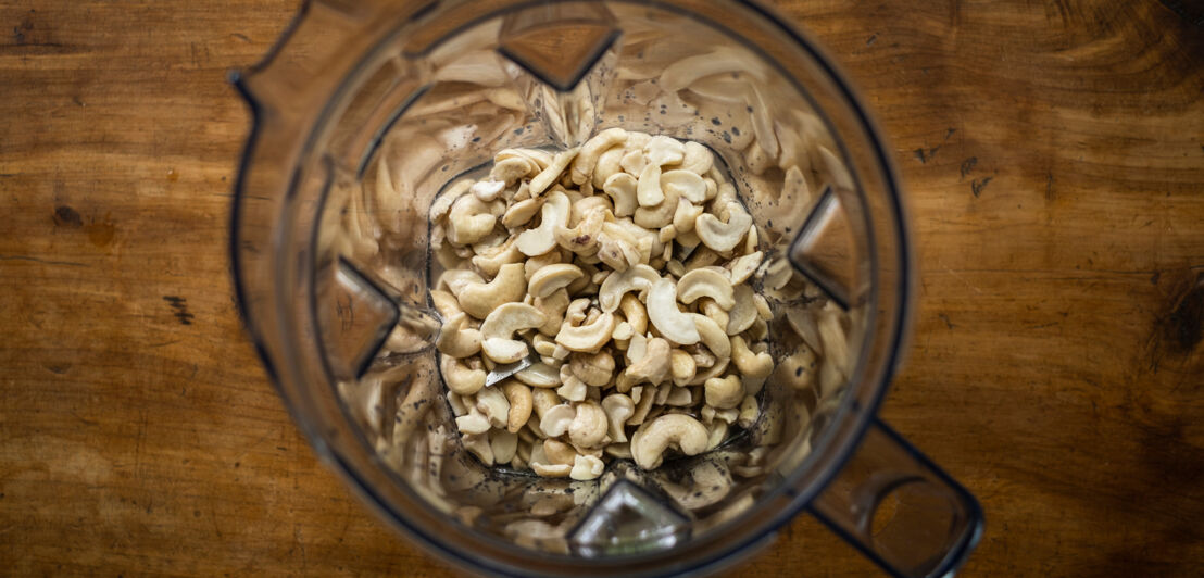 In einem Glasbehälter liegen mehrere Cashewnüsse.