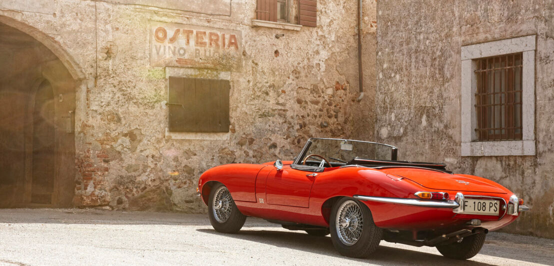 Ein Jaguar E-Type vor einer Osteria