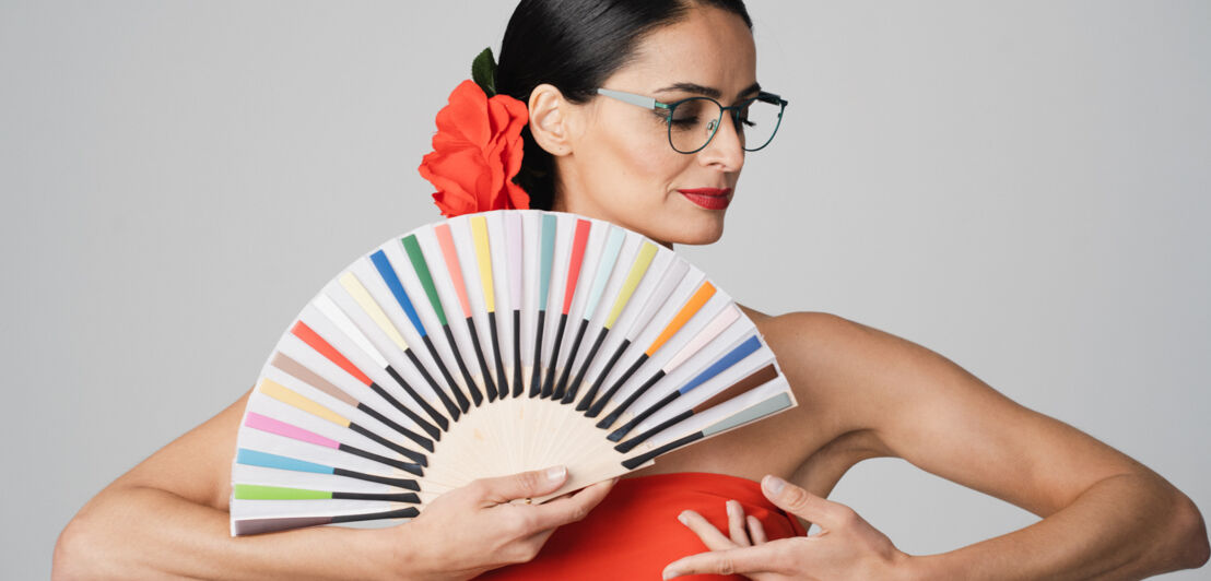 Eine Frau im Flamenco-Look mit einem Fächer aus Brillenbügeln