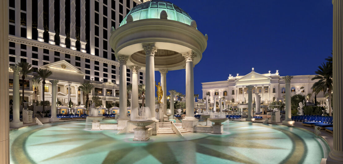 Pool im Caesars Palace mit Marmorsäulen und Beleuchtung.