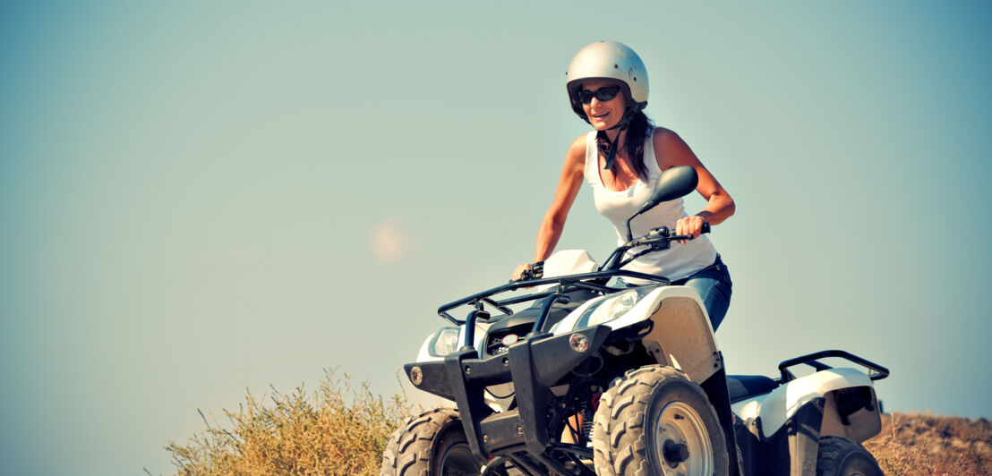 Eine Frau mit Helm auf einem Quad