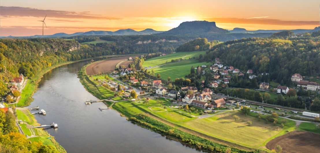 Blick über die Elbe mit dem Königstein im Hintergrund, hinter dem die Sonne untergeht