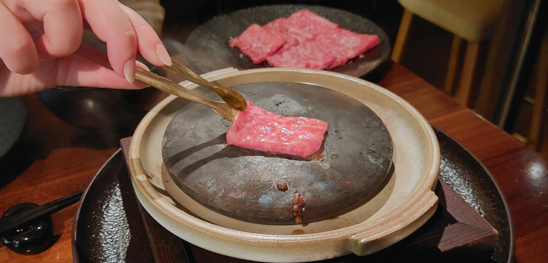 Ein dünnes Stück Wagyu wird auf einem heißen Stein zubereitet