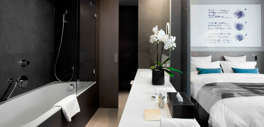 Modernes Hotelzimmer mit Badewanne und Bett