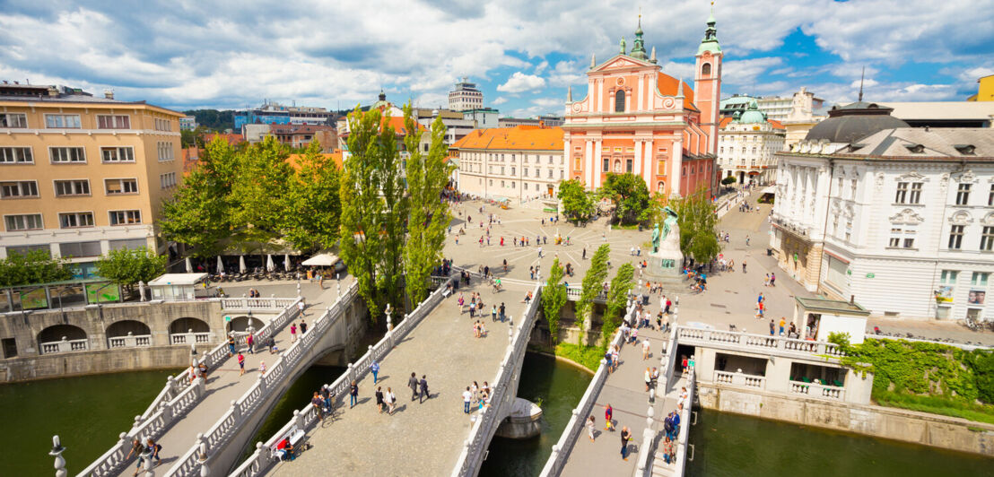 Blick auf die Drei Brücken in Ljubljana mit der Franziskanerkirche im Hintergrund.