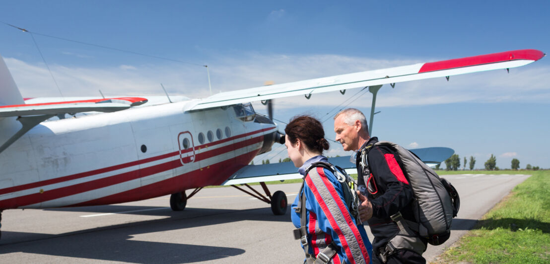 Zwei Personen laufen auf ein Flugzeug zu