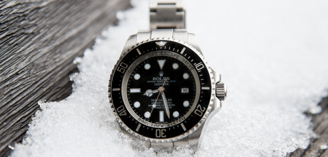 Rolex Oyster Perpetual Deepsea vor vereistem Schnee auf einem Holzbrett