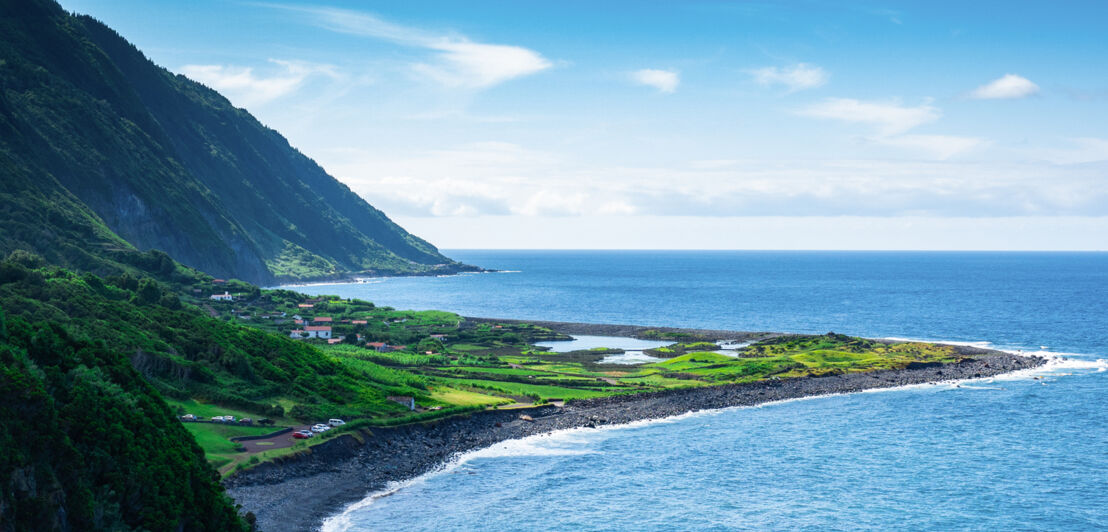 Steilküste und flache Landzunge, die ins blaue Meer hineinragt