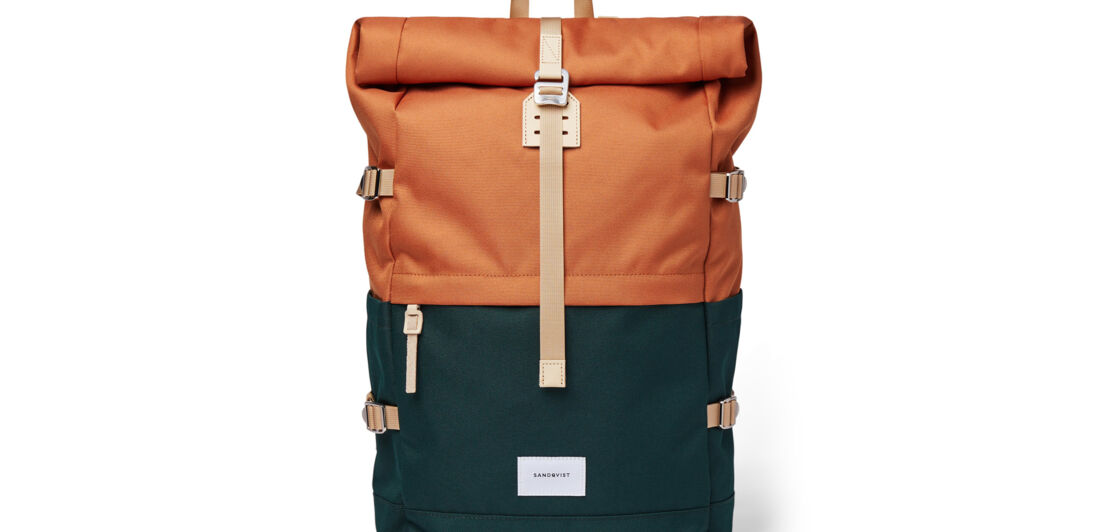 Ein Rolltop-Rucksack von Sandqvist in den Farben Schwarz und Orange