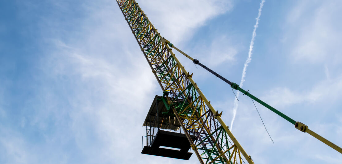 Eine Bungee-Jumping-Kabine, die an einem Kran hängt.