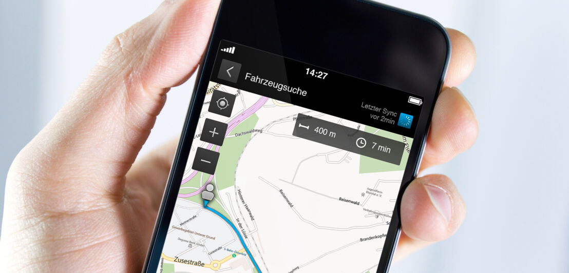 Ein Smartphone zeigt den Weg zu einem Auto.