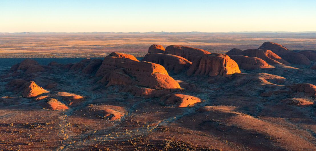 Luftaufnahme von gigantischen Sandsteinfelsen in einer Wüstenlandschaft in der Abendsonne 