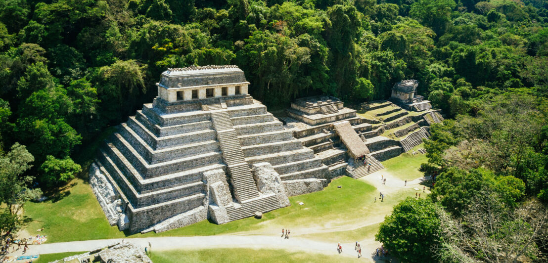 Luftaufnahme einer Treppenpyramide auf einer archäologischen Ruinenstätte mit Besuchern im Urwald