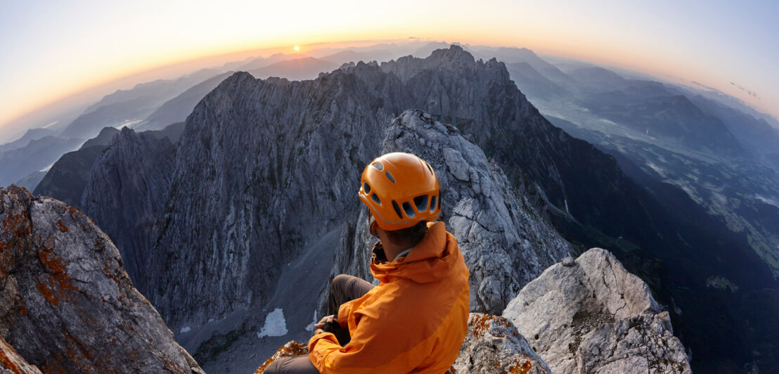 Ein Kletterer auf einem Berggipfel