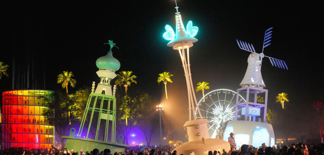 Beleuchtete und bunte Türme beim Coachella-Festival bei Nacht.