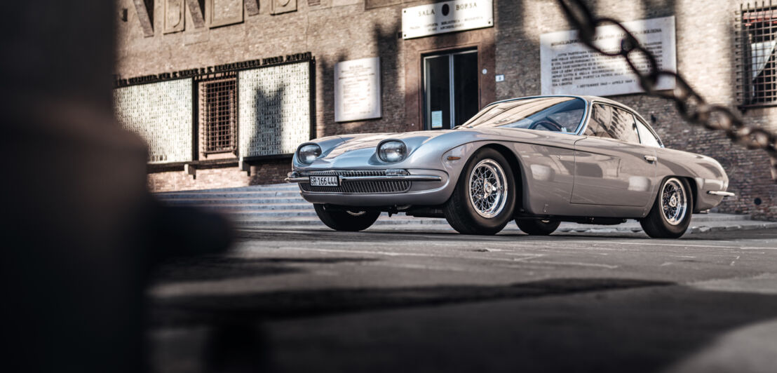 Ein silberner Oldtimer in einer alten Stadt