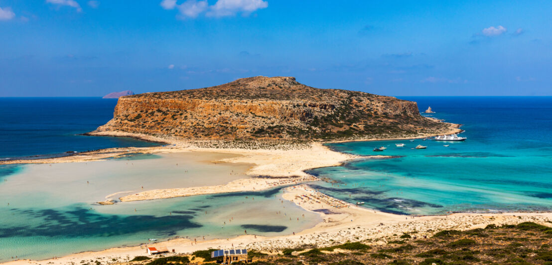 Panorama einer Lagune mit mediterraner Vegetation mit Badegästen auf den Sandbänken