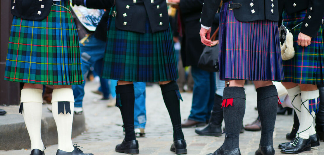 Männer in unterschiedlich gemusterten Kilts