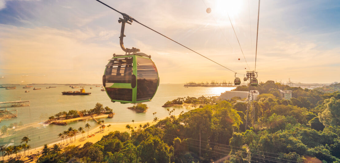 Eine Seilbahn über der tropischen Insel Sentosa Island mit Sandstränden bei Sonnenuntergang