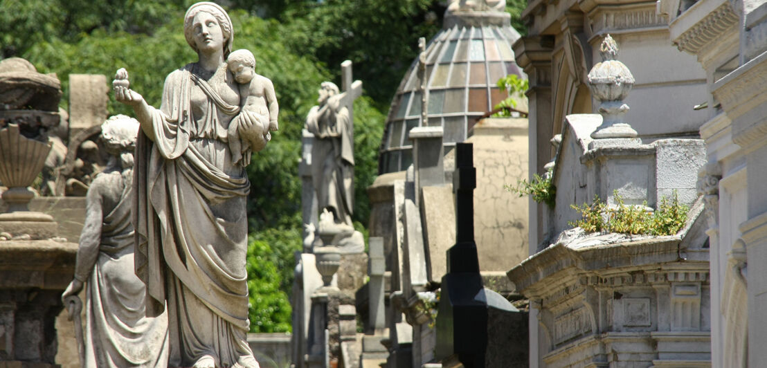 Verzierte Mausoleen mit Steinstatuen auf einem Friedhof