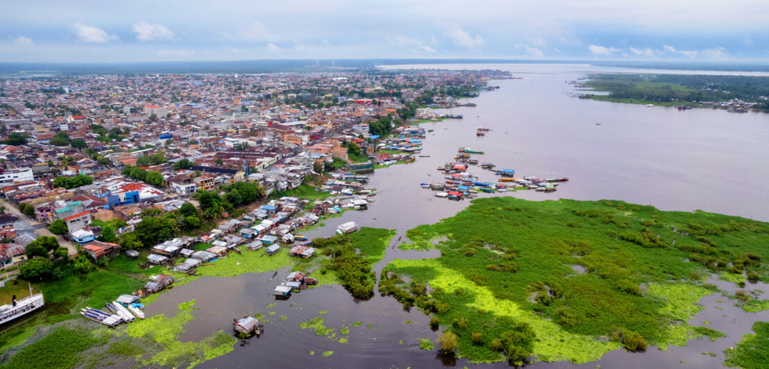 Eine große Stadt, umgeben von Wasser und Regenwald