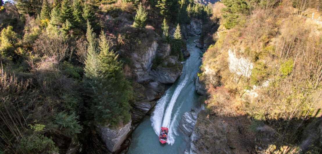 Blick von oben auf ein rotes Boot auf dem Shotover River