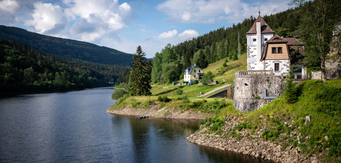 Ein See in einer hügeligen Landschaft, am Ufer steht eine Dorfkirche