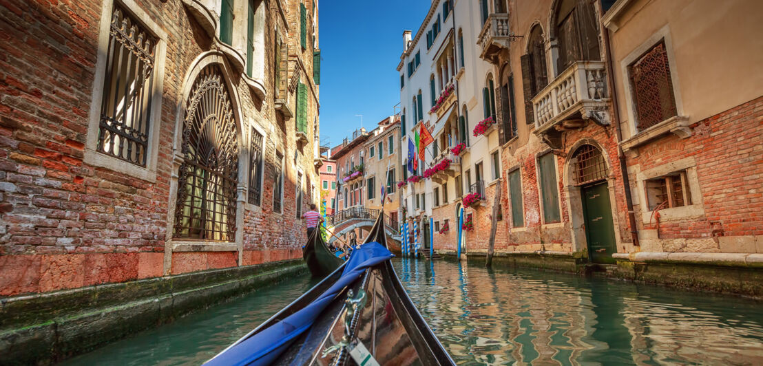 Hausfassaden an einem Wasserkanal in Venedig mit dem Bug einer Gondel im Vordergrund