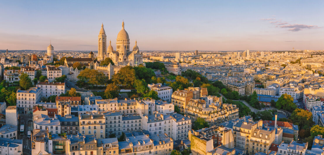 Luftaufnahme des Montmartre-Hügels mit der Basilique du Sacre-Coeur in Paris bei Sonnenuntergang