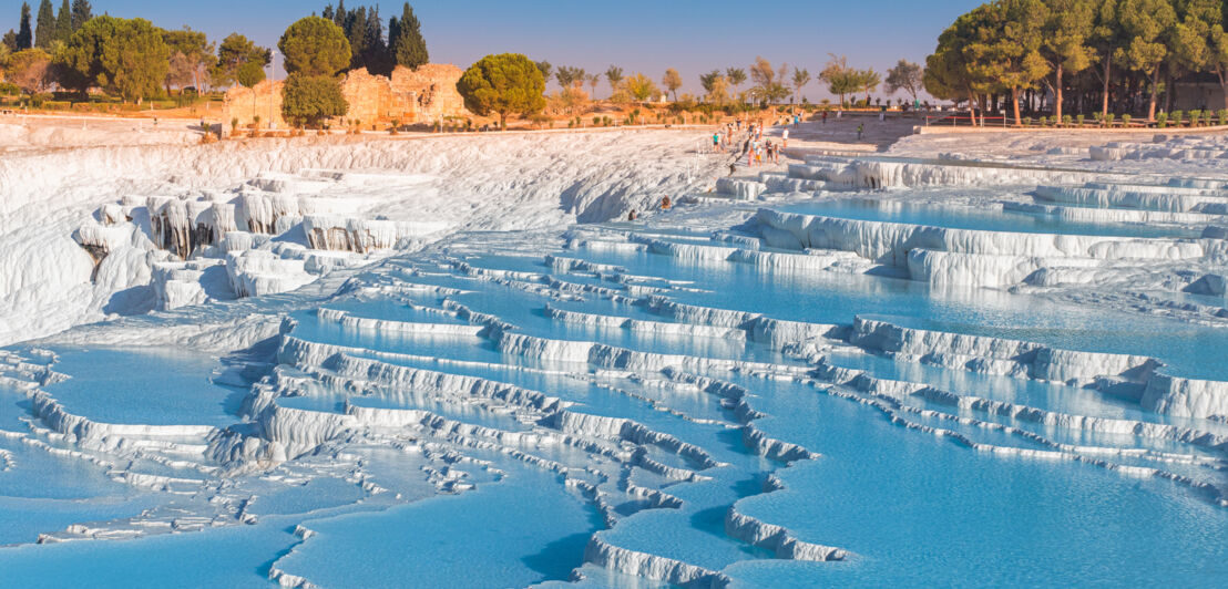 Besucher vor mit Wasser gefluteten Kalkterrassen in Pamukkale.