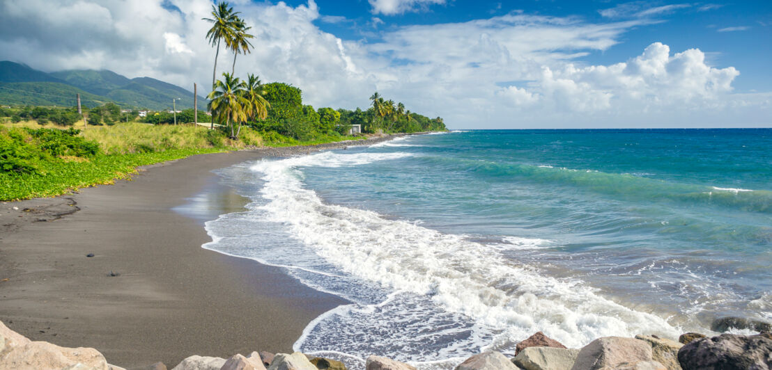 Ein schwarzer Sandstrand auf der Insel St. Kitts.